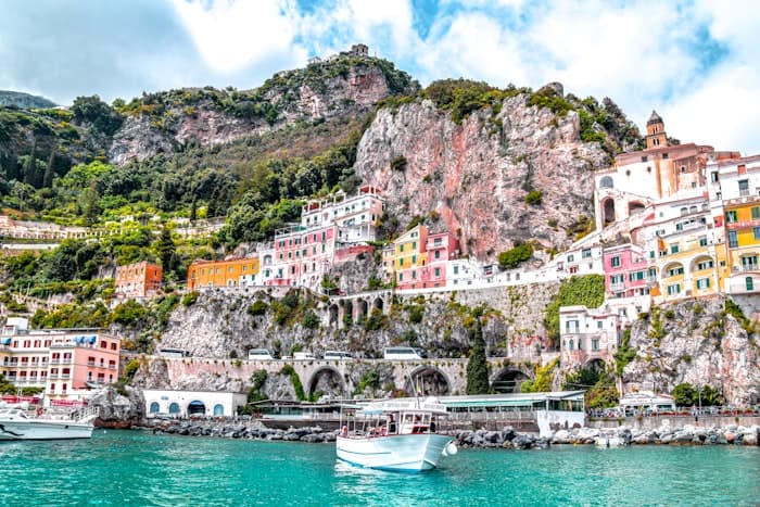 Colourful houses stacked above a small harbour on the Amalfi Coast